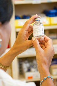 Pharmacist reviewing a lab vial